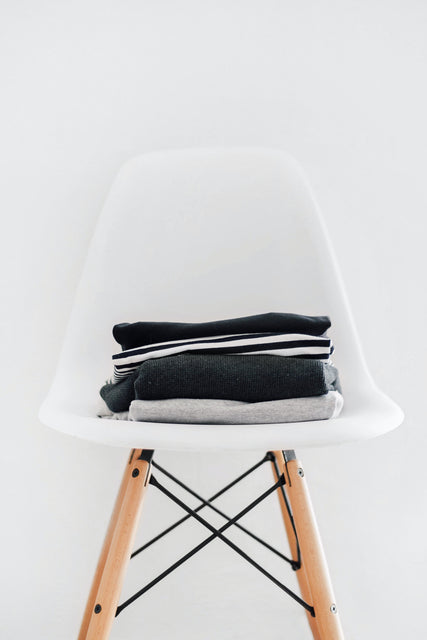 Photo. Folded shirts on a white chair.